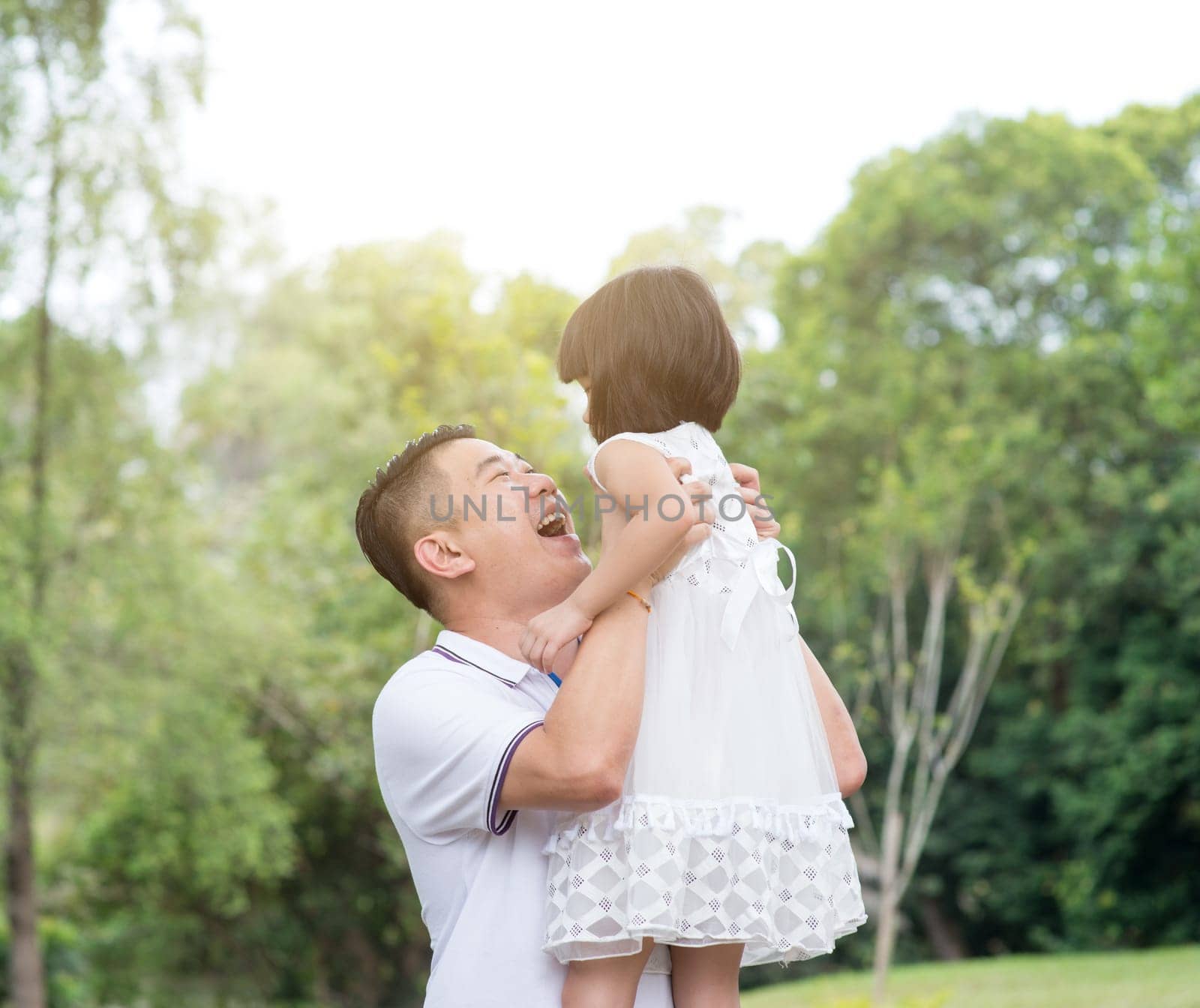 Asian family portrait. Father and daughter having fun at outdoor park.