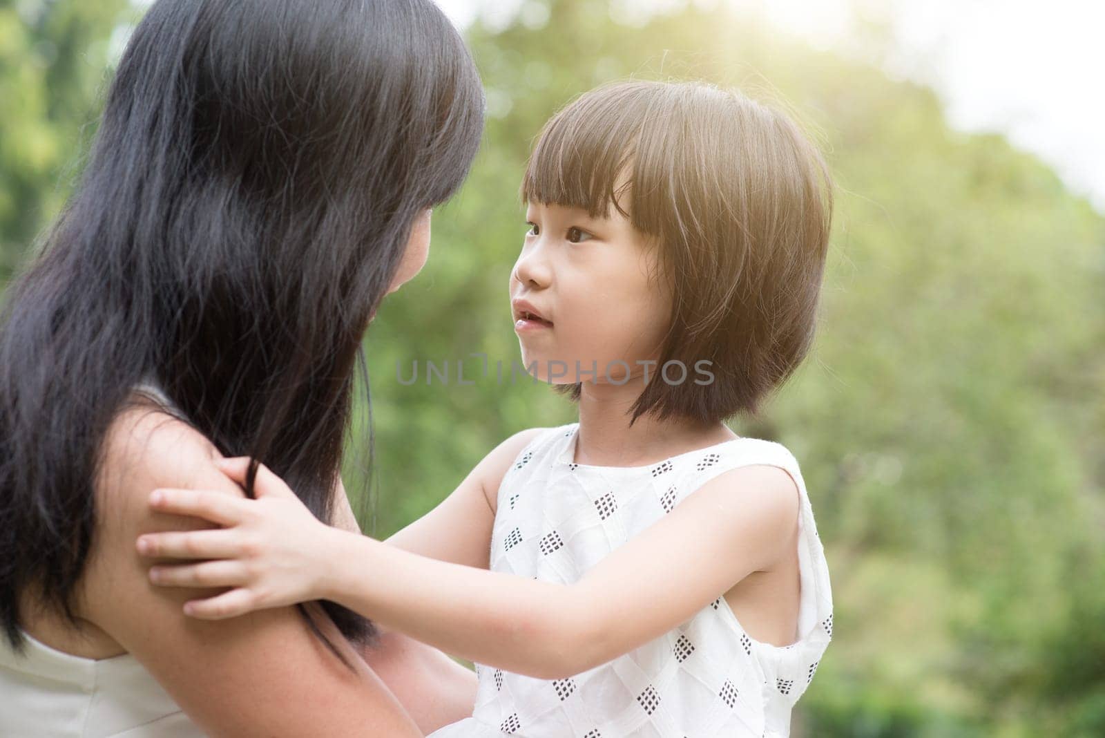 Asian family outdoors portrait. Mother and daughter enjoying at garden park.