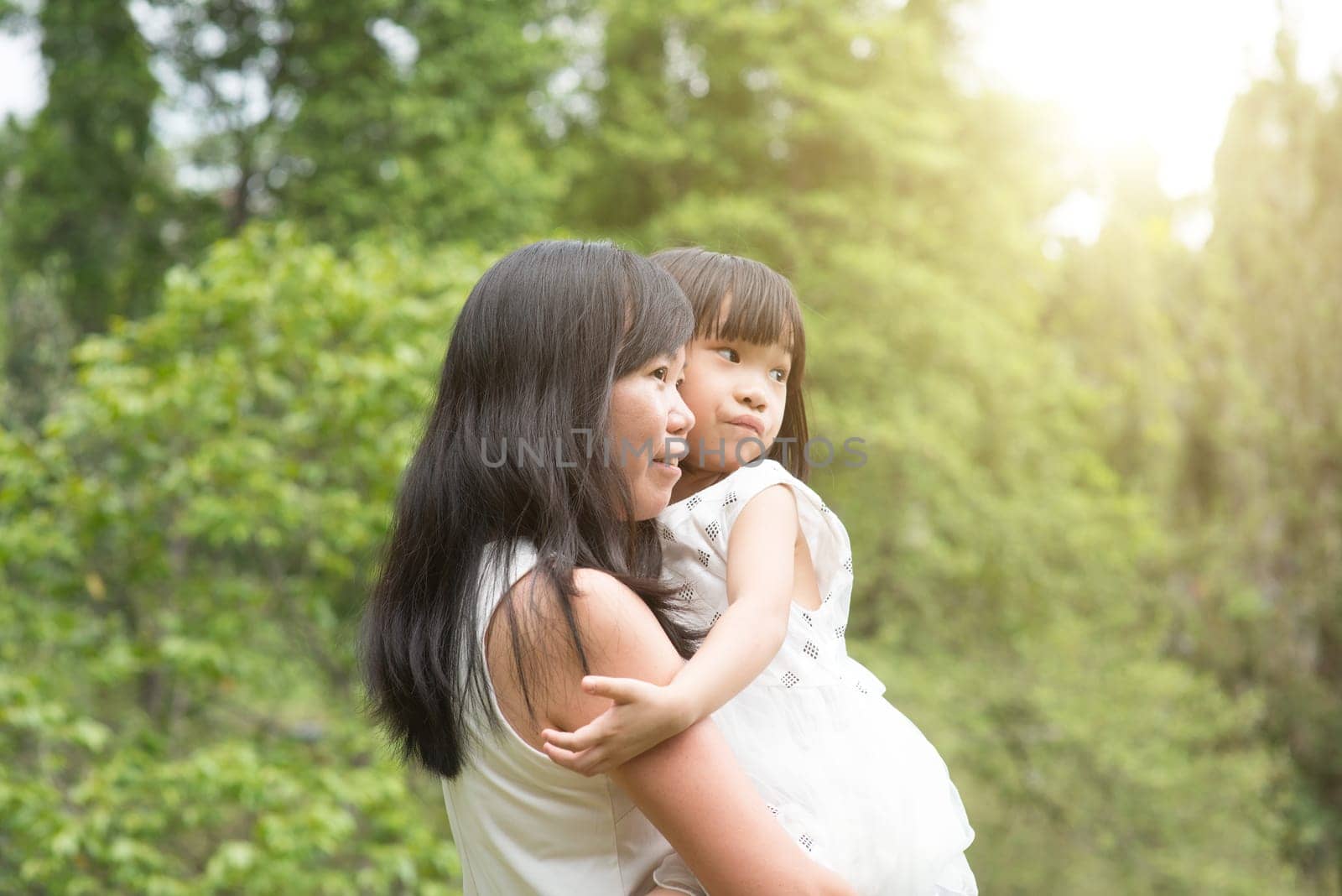 Asian family outdoors portrait. Mother and daughter at garden park.