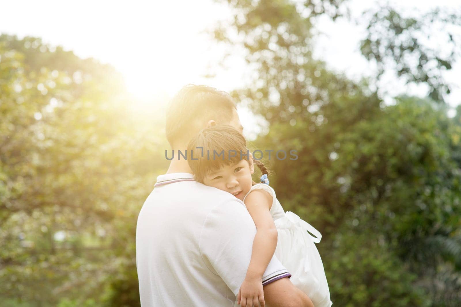 Asian family outdoors portrait. Father and daughter at green park.