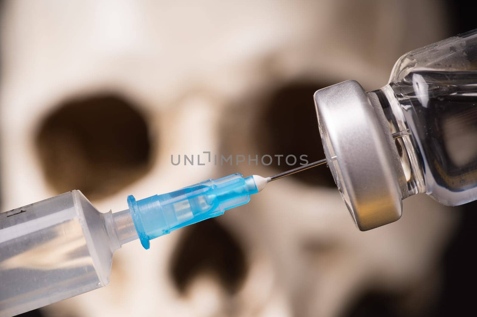 medical vials, syringe and blurry skull close up