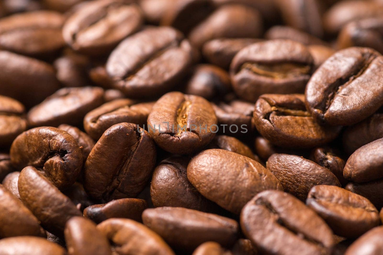Roasted organic whole dark coffee beans, close up
