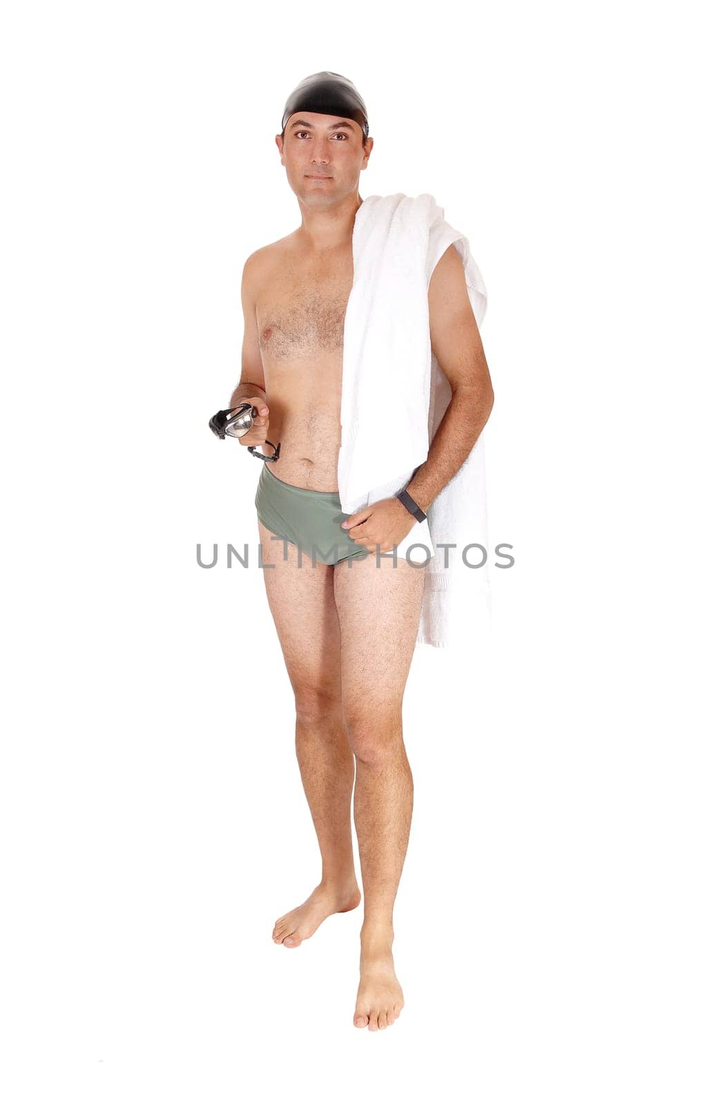 A tall handsome man in a green swimsuit standing from the front.with his towel and swim google and cap isolated on white background.