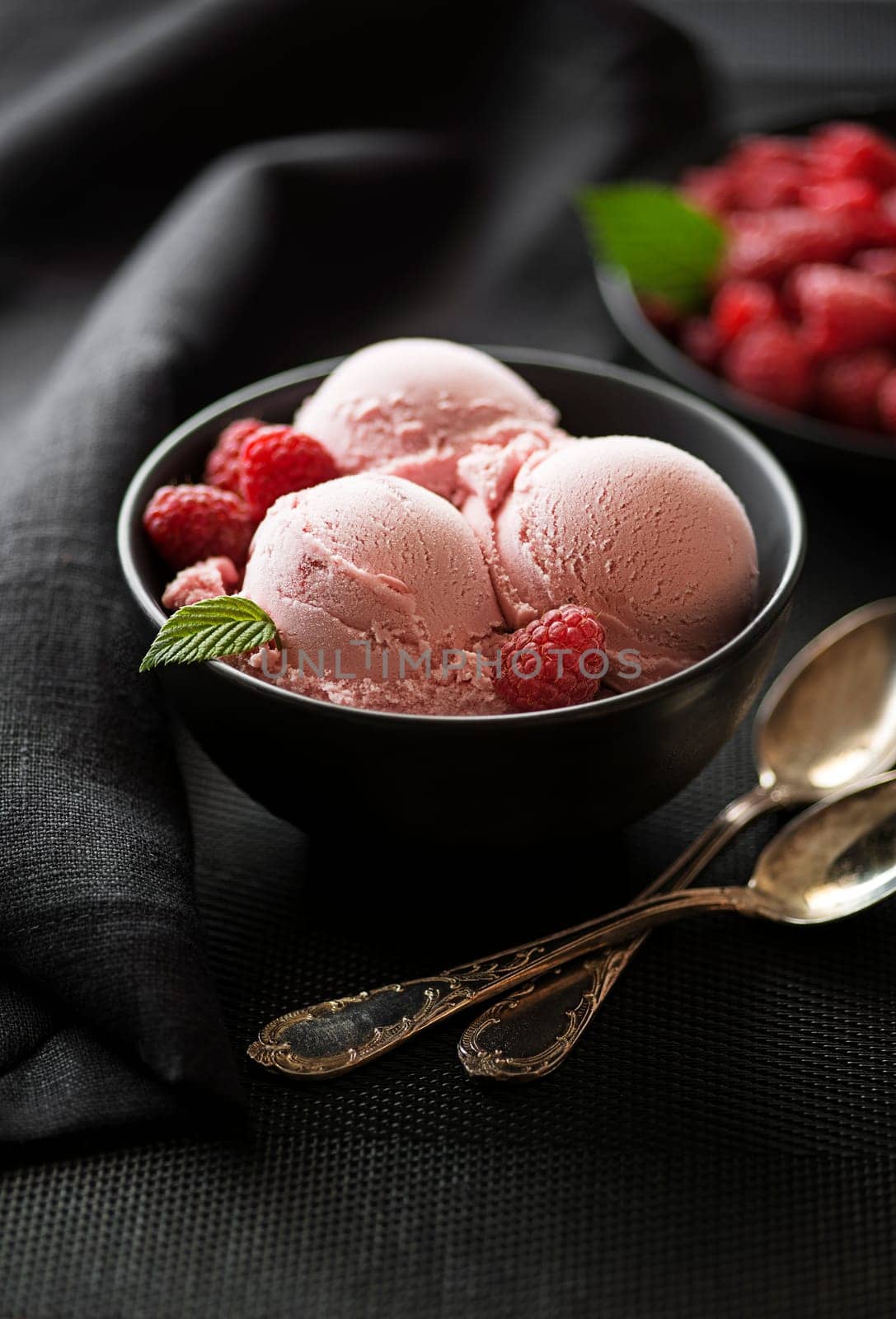 Homemade organic Raspberry ice cream scoops in black bowl