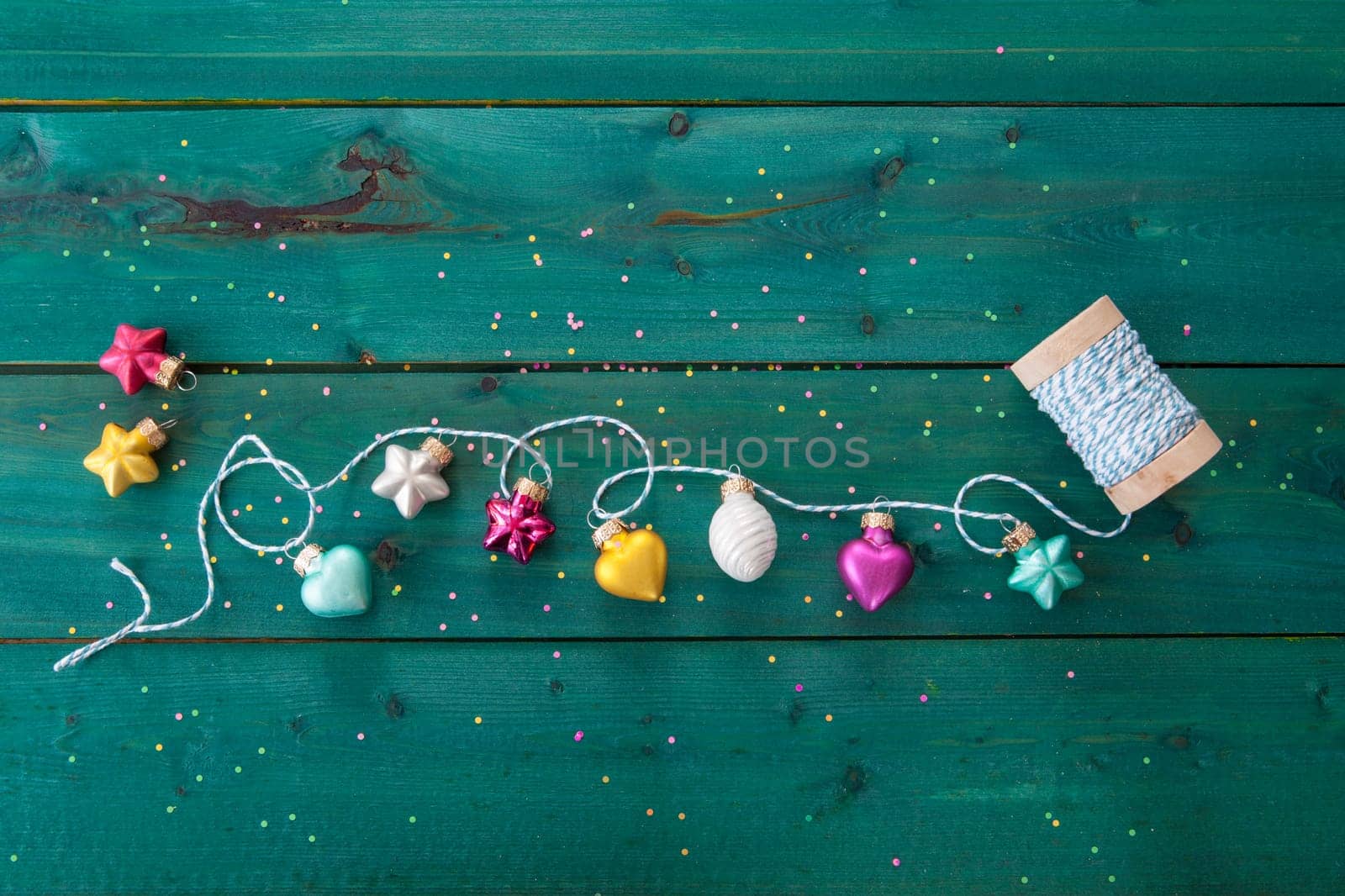 Cheerful christmas garland made from baubles on wooden background