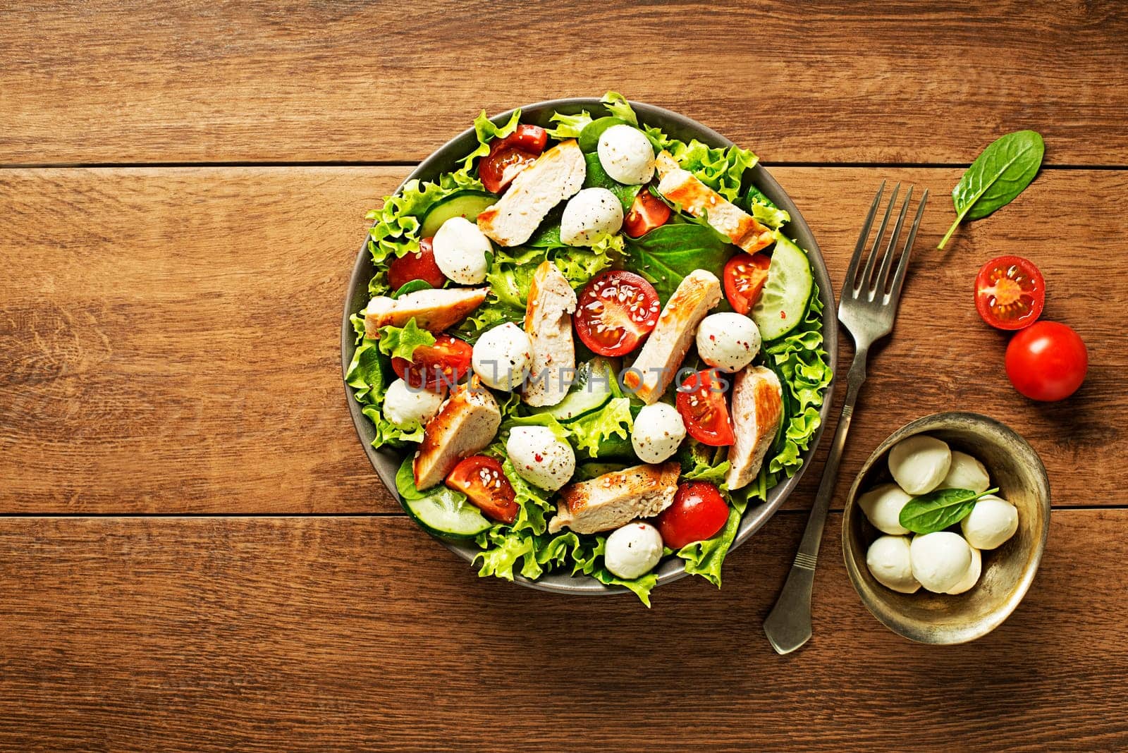 Fresh green salad with chicken breast tomato and mozzarella cheese