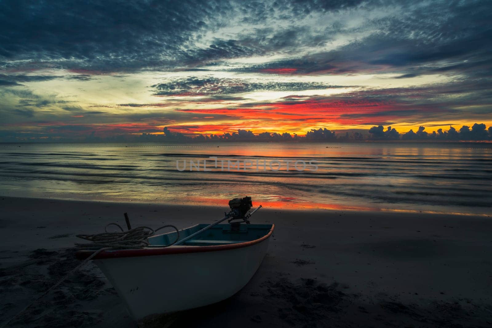 A beautiful dawn on a topical beach with a boat.