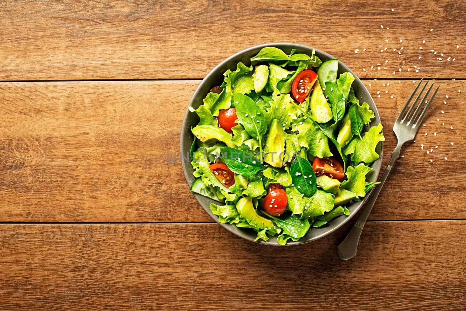 Fresh green lettuce salad with avocado and tomato