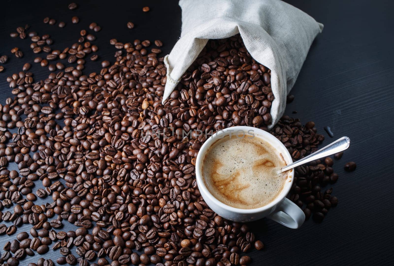 Photo of coffee cup, coffee beans and canvas bag.