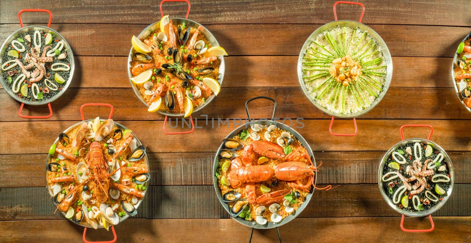 Assorted paella on wooden table, above view