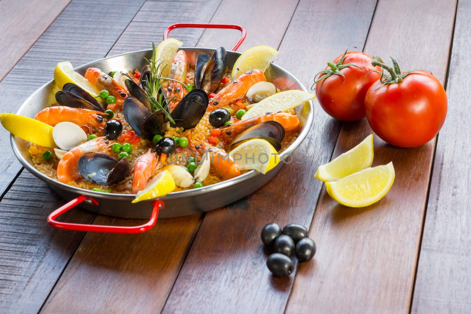 Paella with seafood vegetables and saffron served in the traditional pan.
