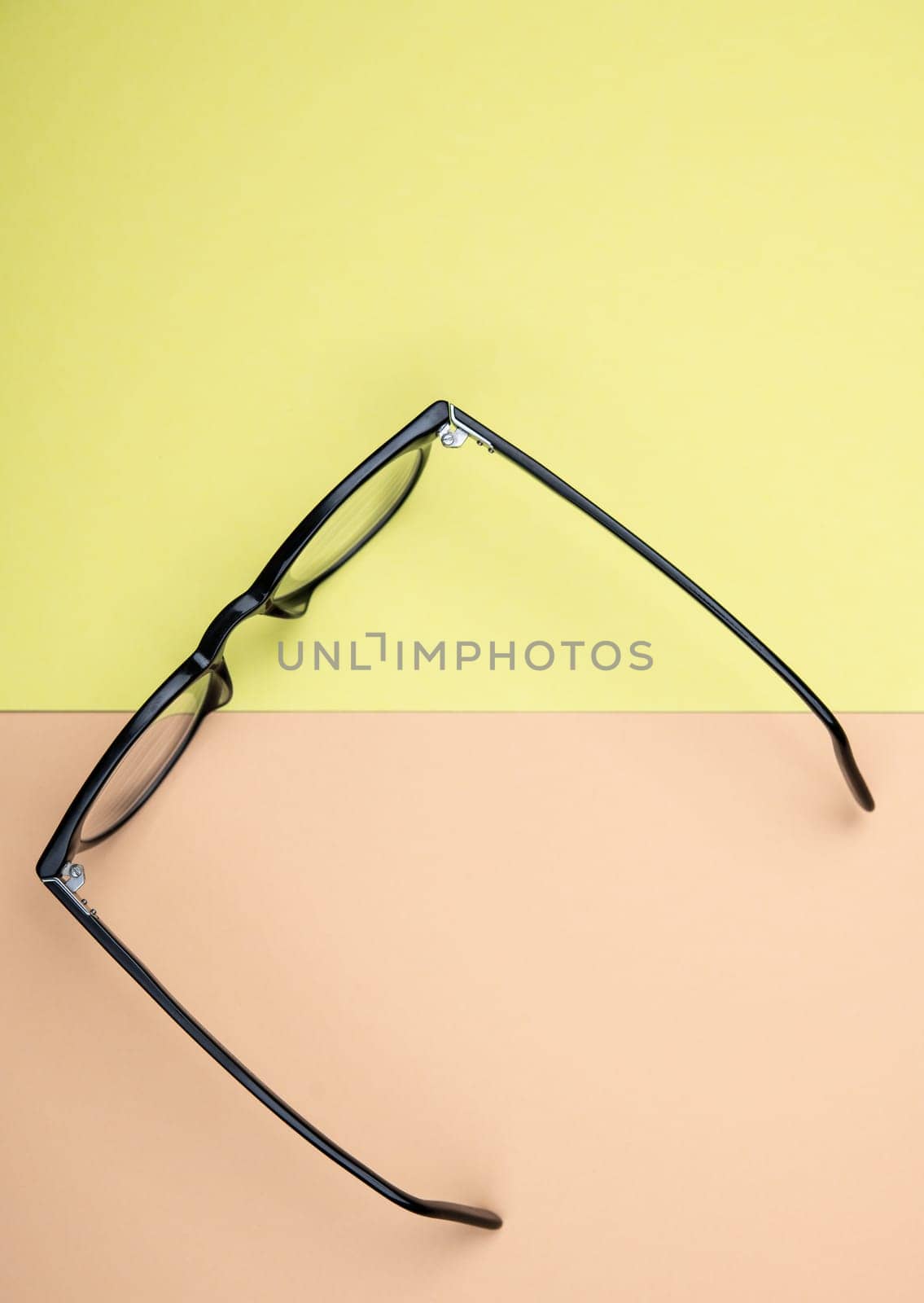 black glasses on yellow and orange ground from above