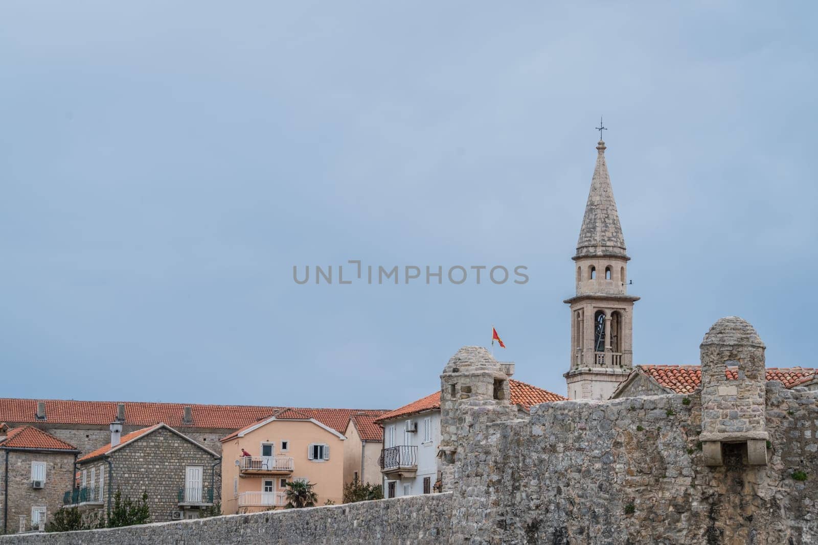 Budva, Montenegro - April 2018 : Church tower and high walls of the old town fort