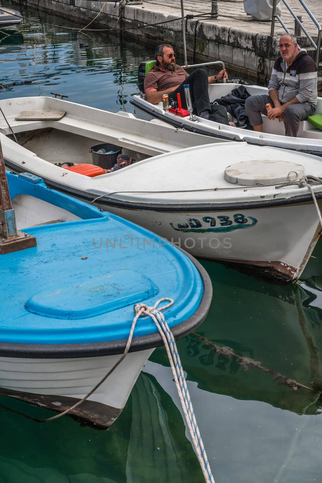 Budva, Montenegro - April 2018 : Men drinking beer in a boat in the port in Budva town