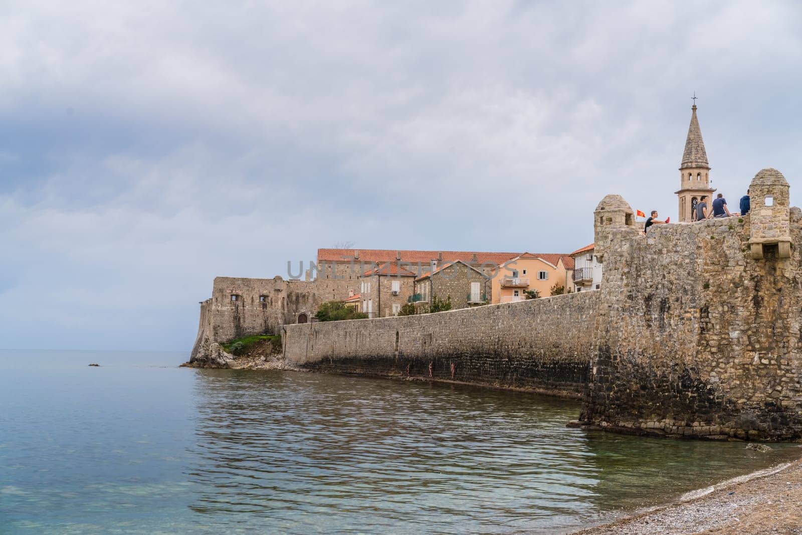 Budva, Montenegro - April 2018 : People sitting on the top of high walls of the old town fort