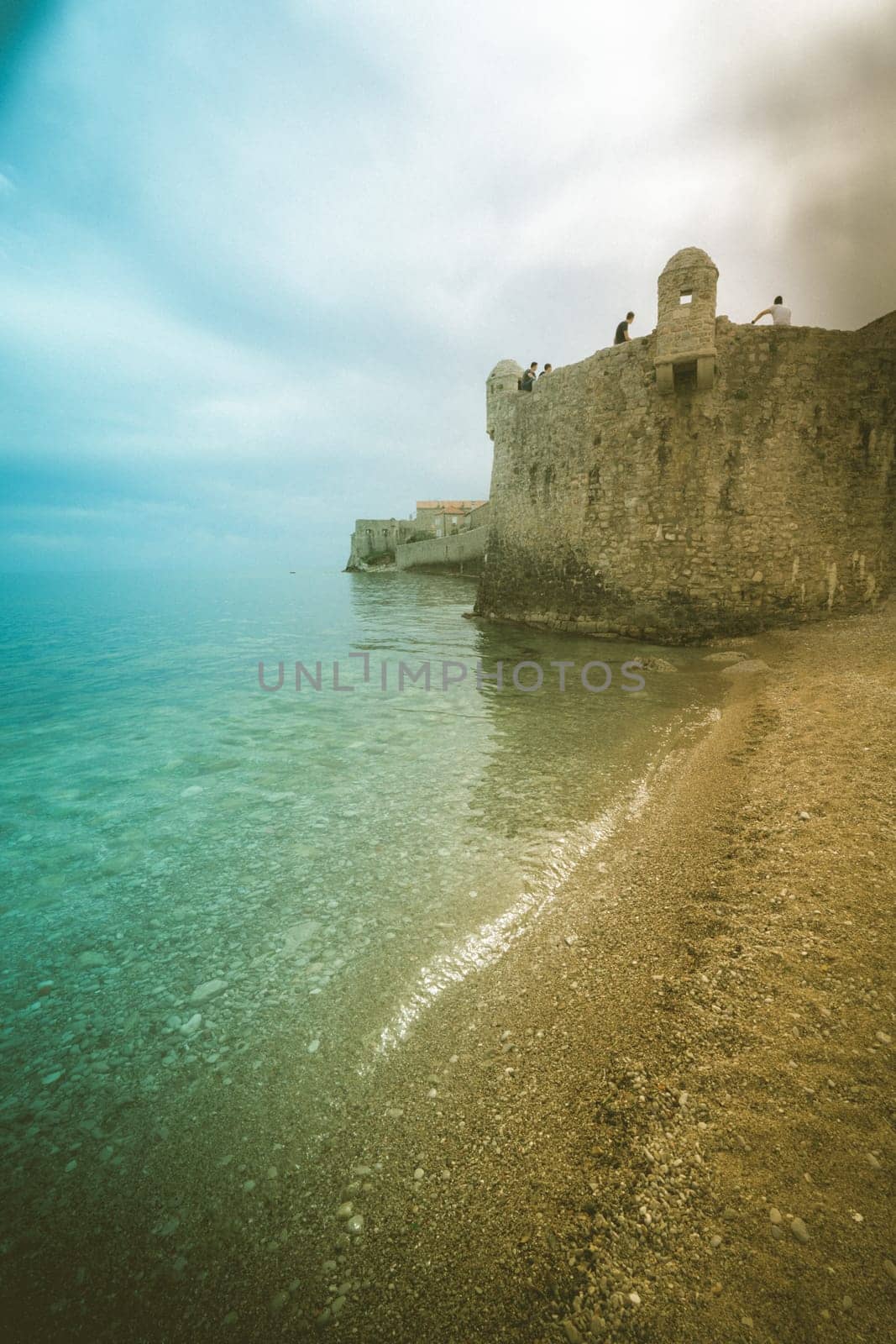 Budva, Montenegro - April 2018 : People sitting on the top of high walls of the old town fort