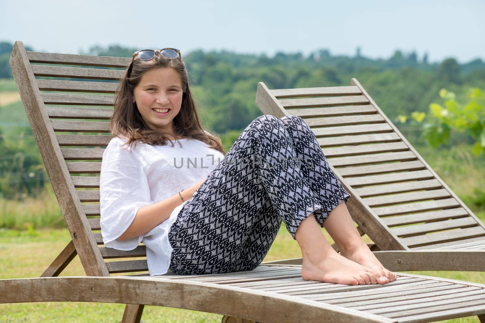 a teenage girl lying on a lounger in the garden