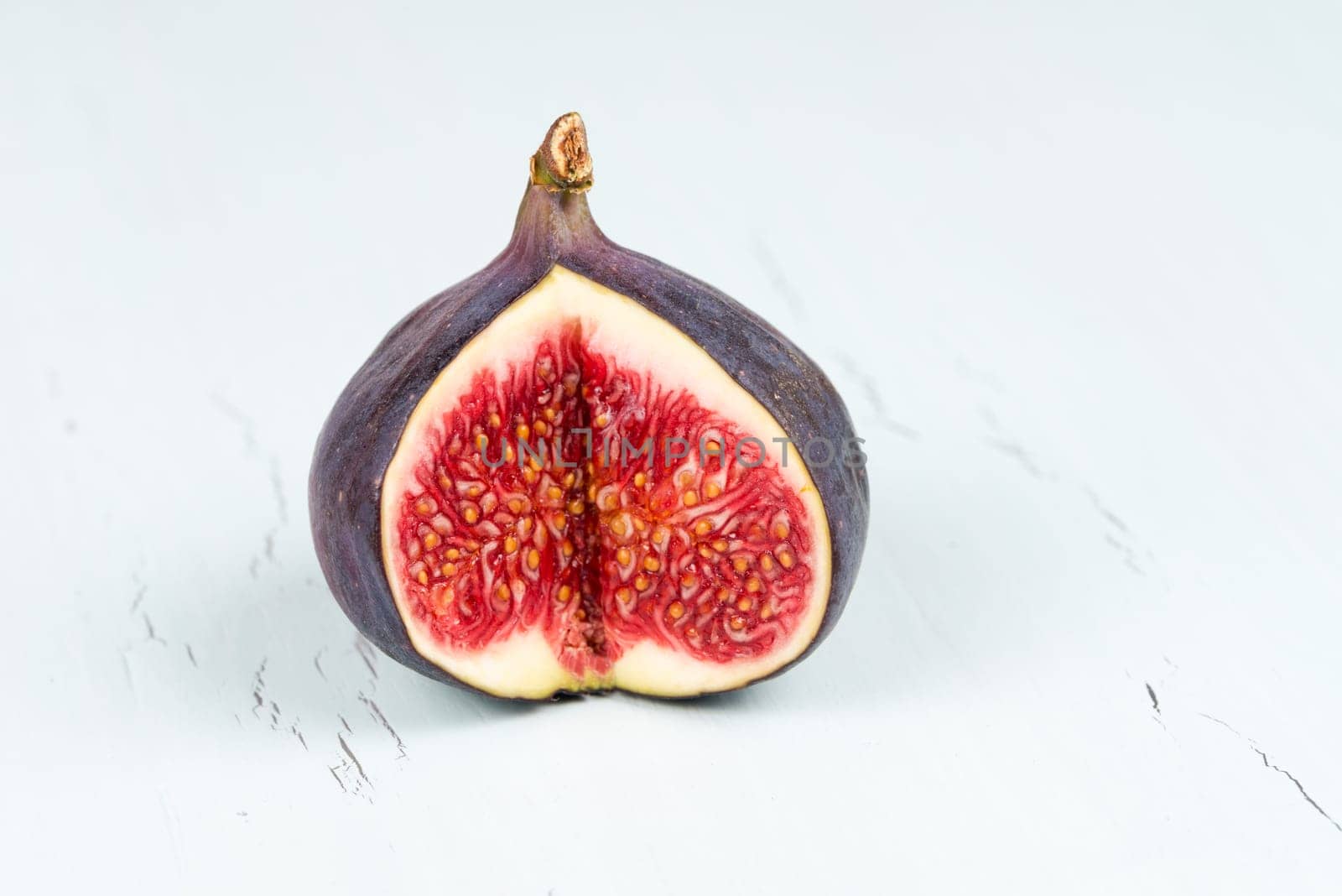 One whole wit a cutout ripe, delicious and sweets figs on a light blue vintage background