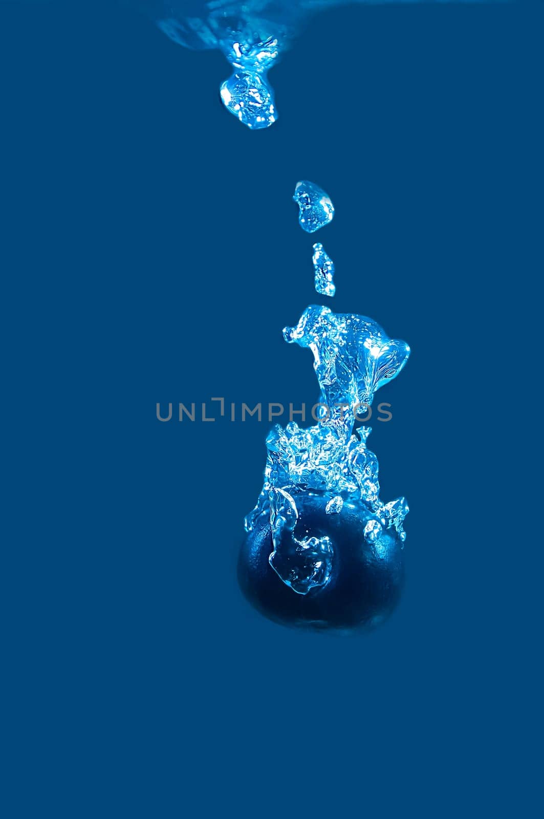 Cherry dark color falls into the blue water.