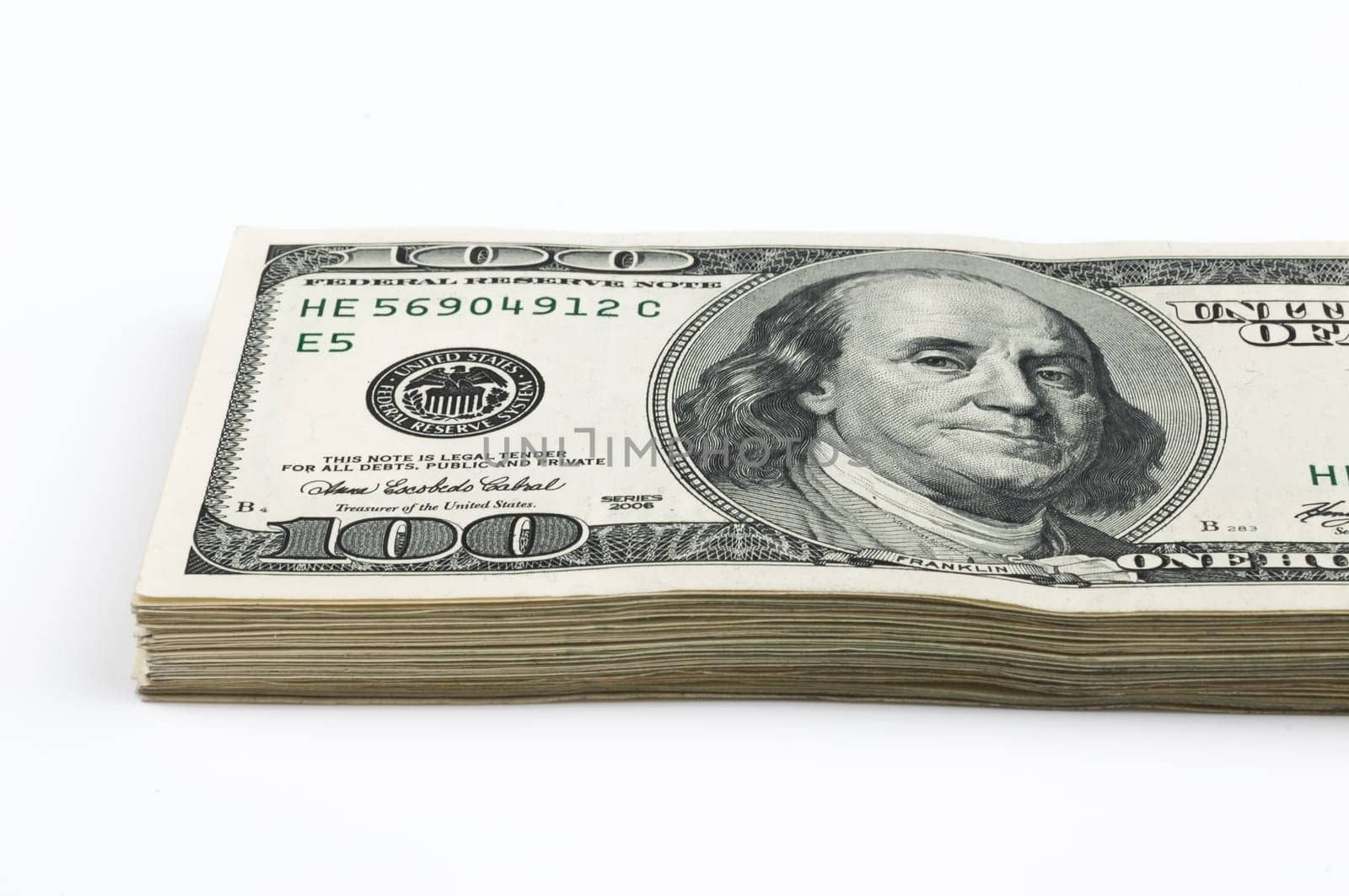 Part of a pack of one hundred dollar bills. View at an angle. Close-up. Isolated.