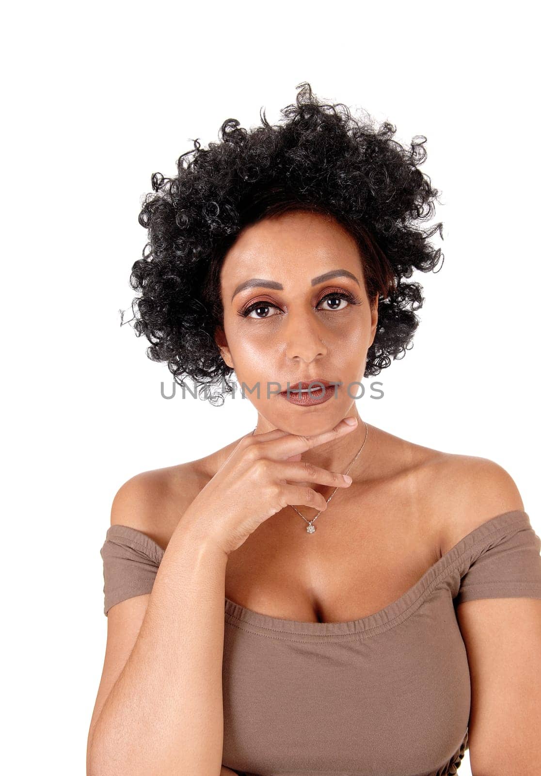 A close up portrait of a woman in a brown dress with fussy black hair.on hand under her chin, isolated for white background.