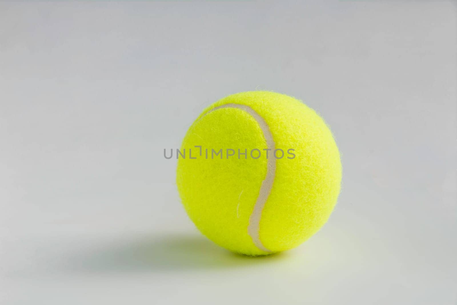 Single yellow tennis ball on the background close up