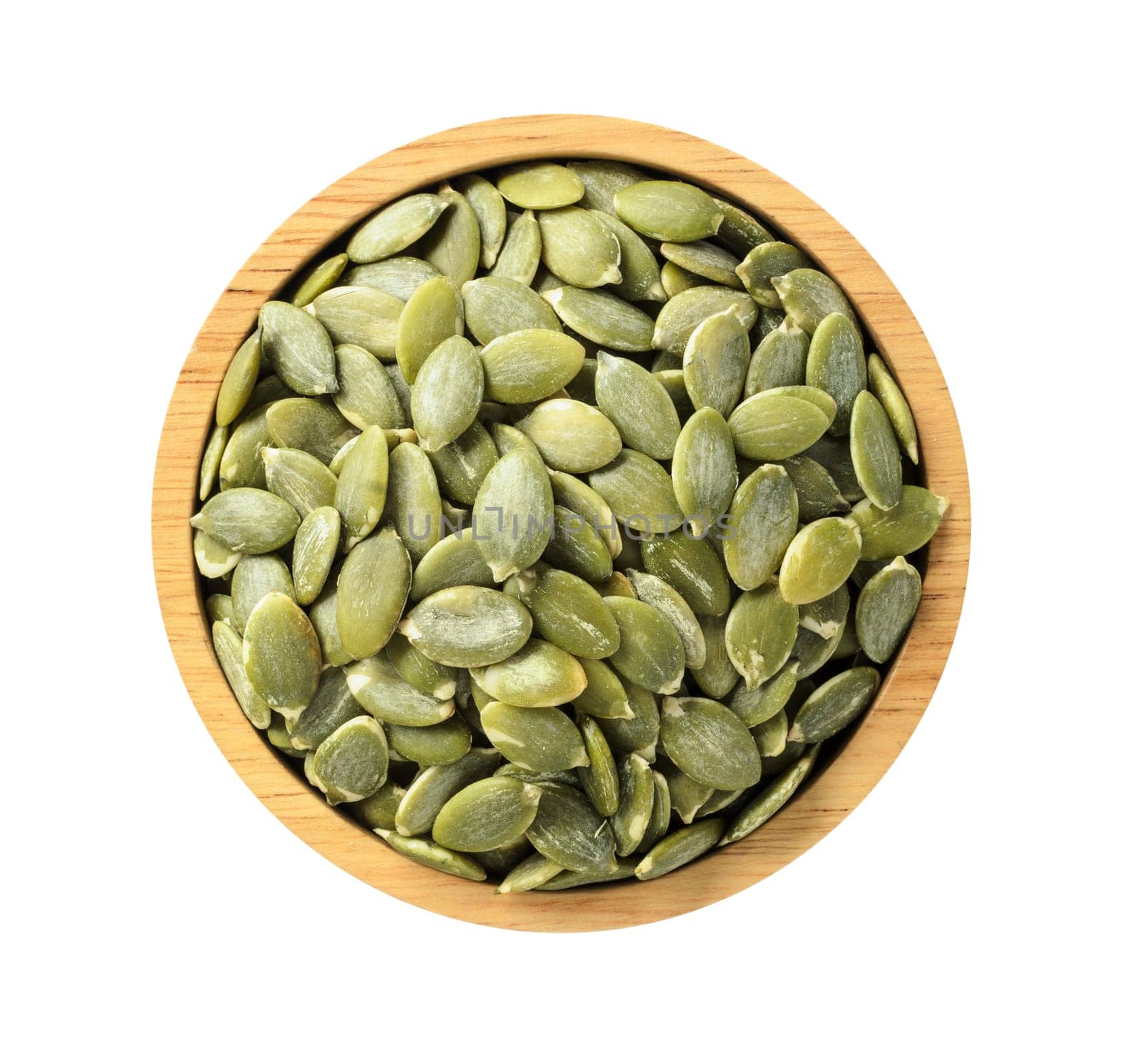 Dry pumpkin seeds in wooden bowl isolated on white background, top view on wooden. Healthy food concept