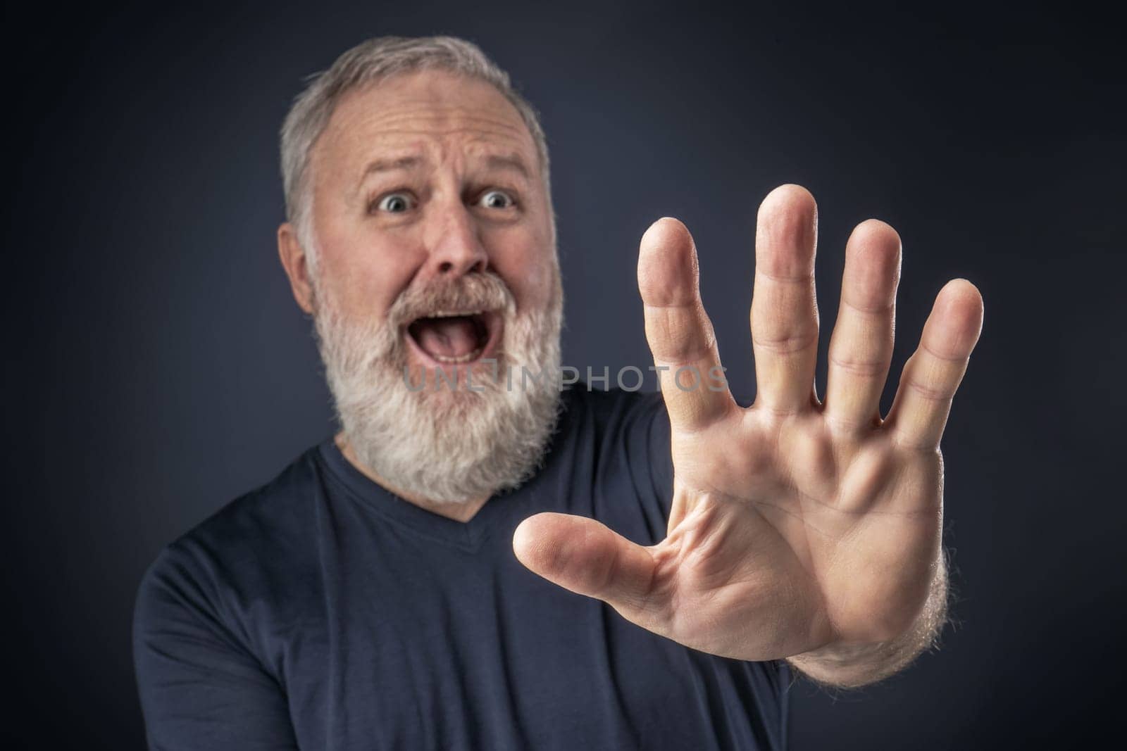 Old man in shirt and scared with his stretched hand forward