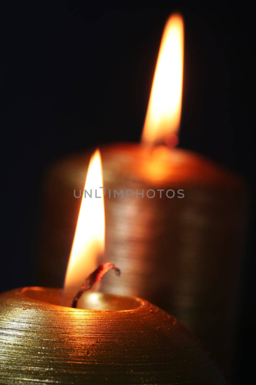 two Christmas-candles light in the darkness
