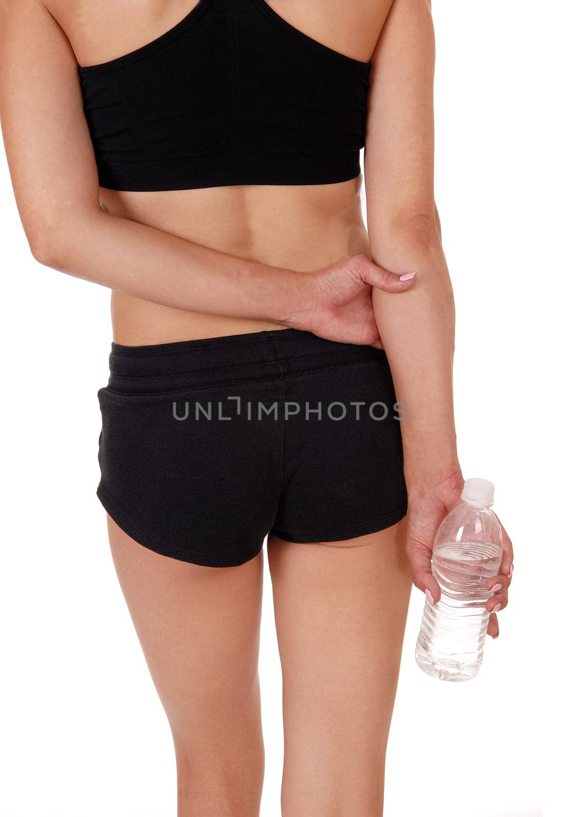 A close up of the back of a woman in black exercise outfit having a .break holding the water bottle, isolated foe white background.