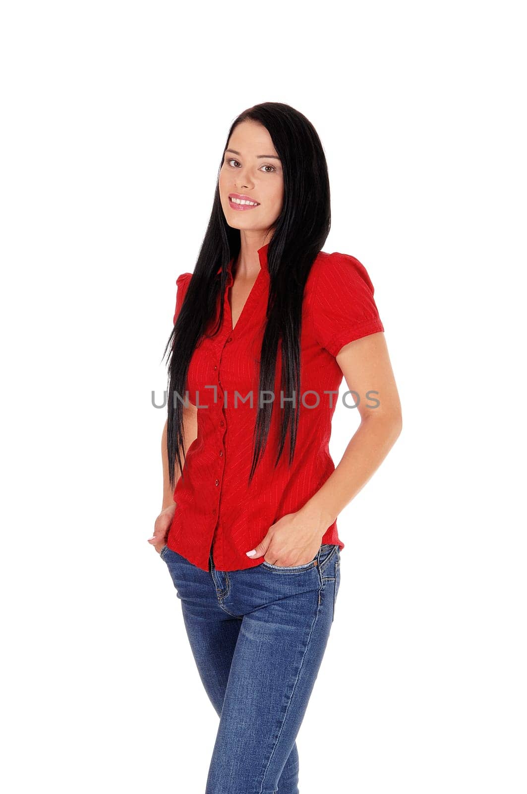 A lovely young woman with long black hair wearing a red blouse and.jeans standing with hands in pocket, isolated for white background.