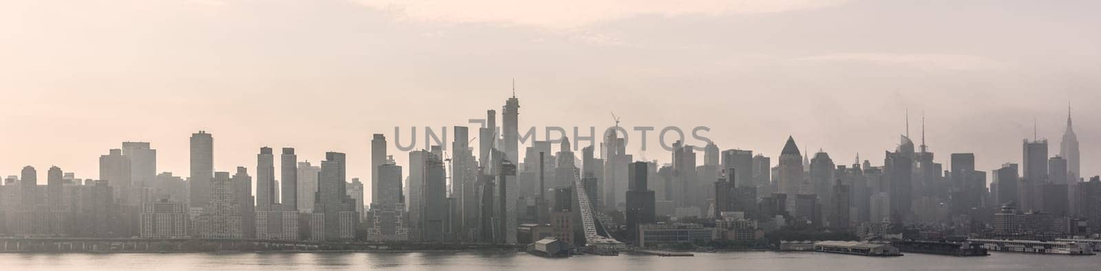 New York City midtown Manhattan skyline panorama view from Boulevard East Old Glory Park over Hudson River on a misty morning.