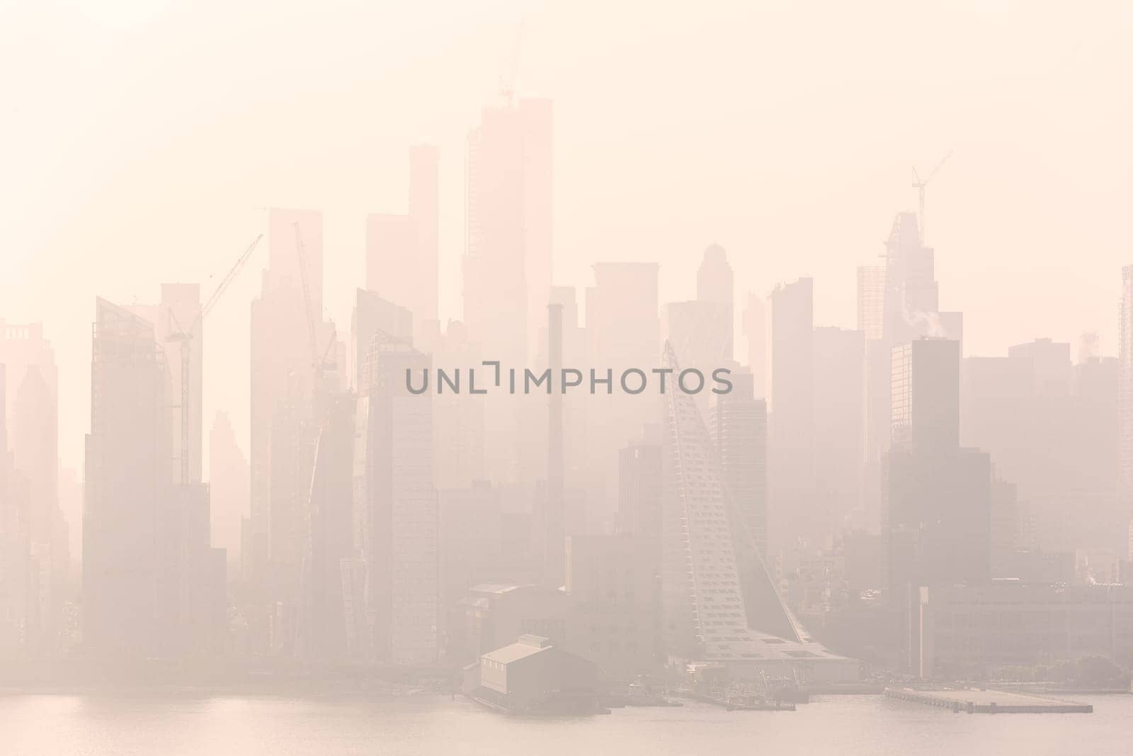 New York City midtown Manhattan skyline panorama view from Boulevard East Old Glory Park over Hudson River on a misty morning.
