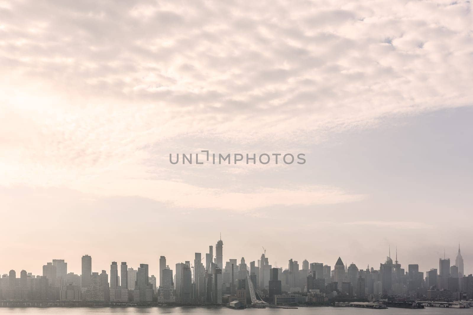 New York City midtown Manhattan skyline panorama view from Boulevard East Old Glory Park over Hudson River on a misty morning.