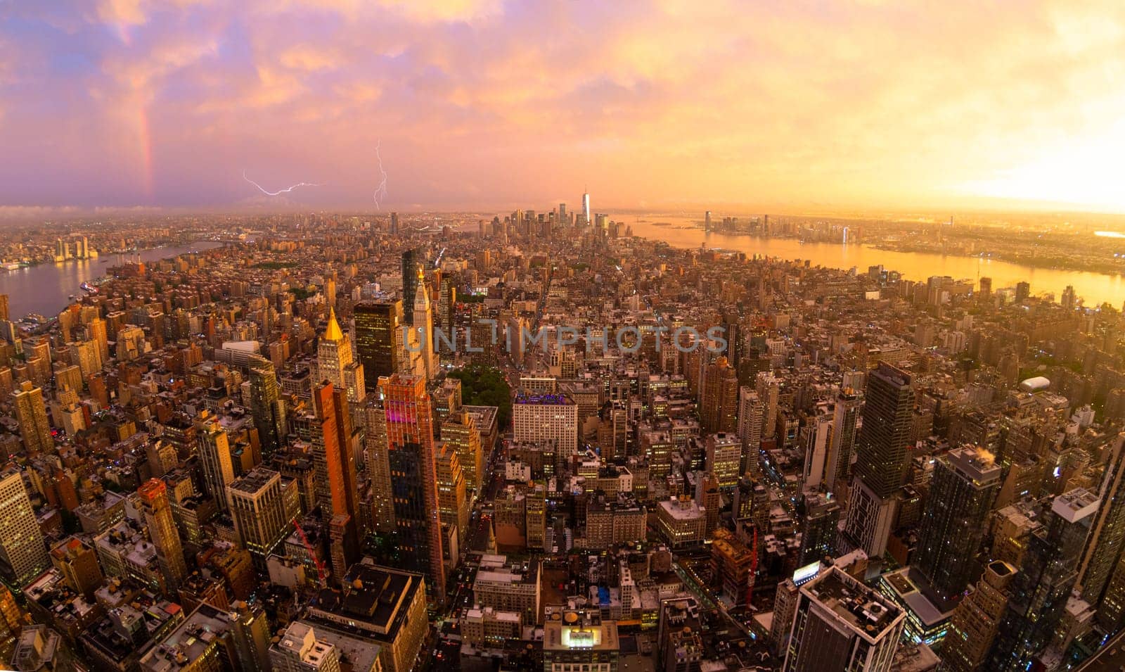 New York City skyline with Manhattan skyscrapers at dramatic vibrant after the storm sunset, USA. Rainbow and lightnings can be seen in background over Brooklyn bridge.