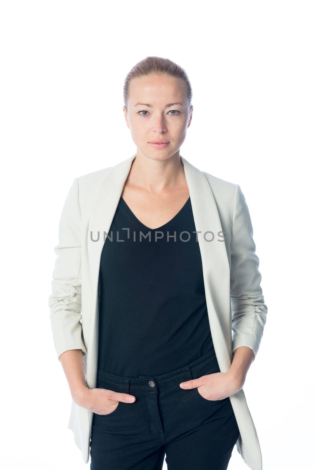 Full body portrait of casualy dressed,cheerful, beautiful, smart, young businesswoman in standing against white background hands in black jeans pockets.