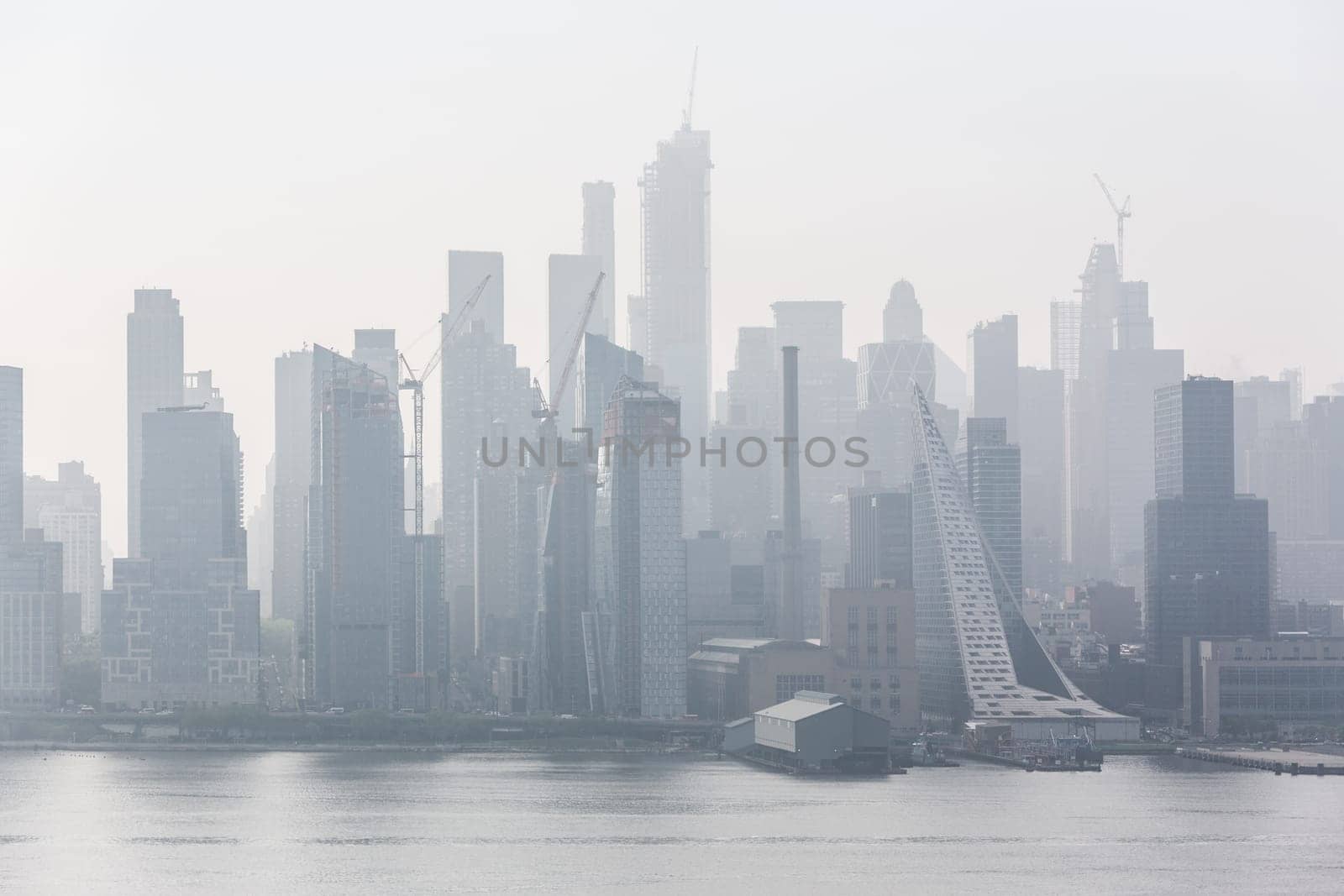 New York City midtown Manhattan skyline panorama view from Boulevard East Old Glory Park over Hudson River on a misty morning.