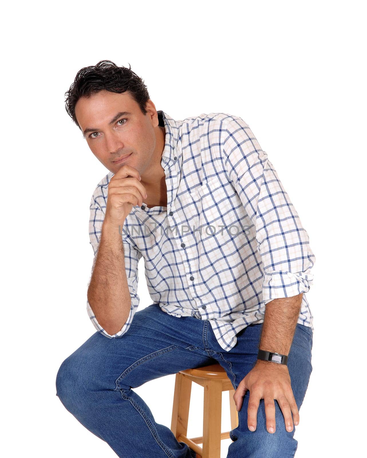 A portrait image of a tall handsome young man sitting on a chair with.his one hand on his chin, isolated for white background..
