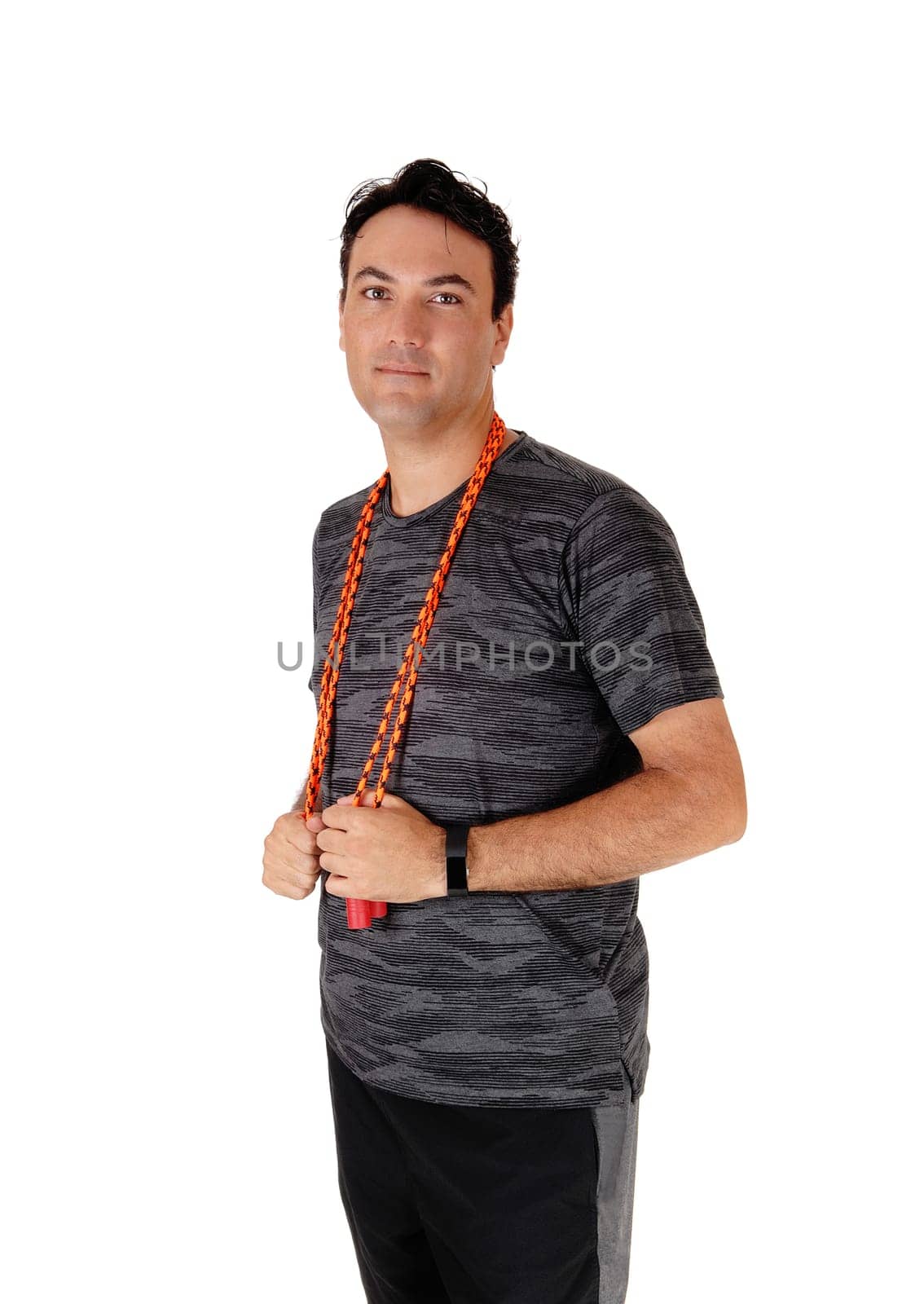 A young man standing in the studio resting from exercising with his .rope, in a sports outfit, isolated for white background.