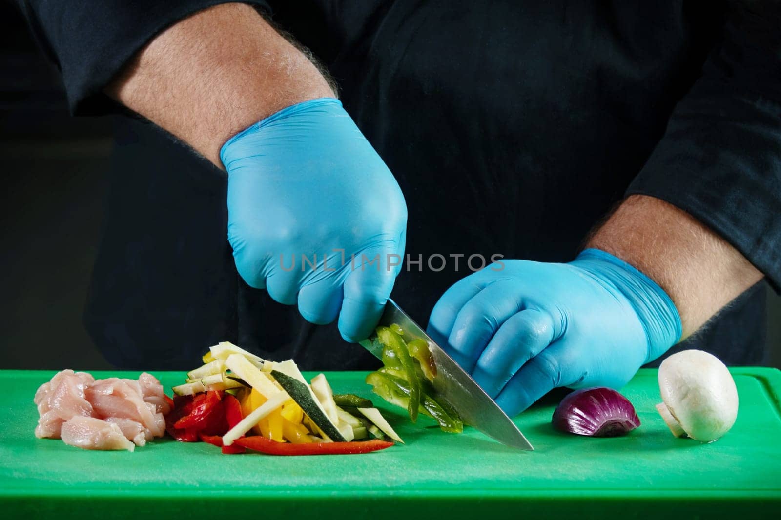 The chef's gloved hands cut the food and prepare them for cooking a specific recipe