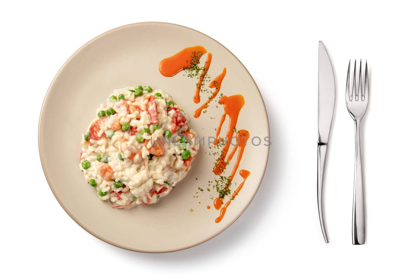 Plate and cutlery with risotto portion on white background