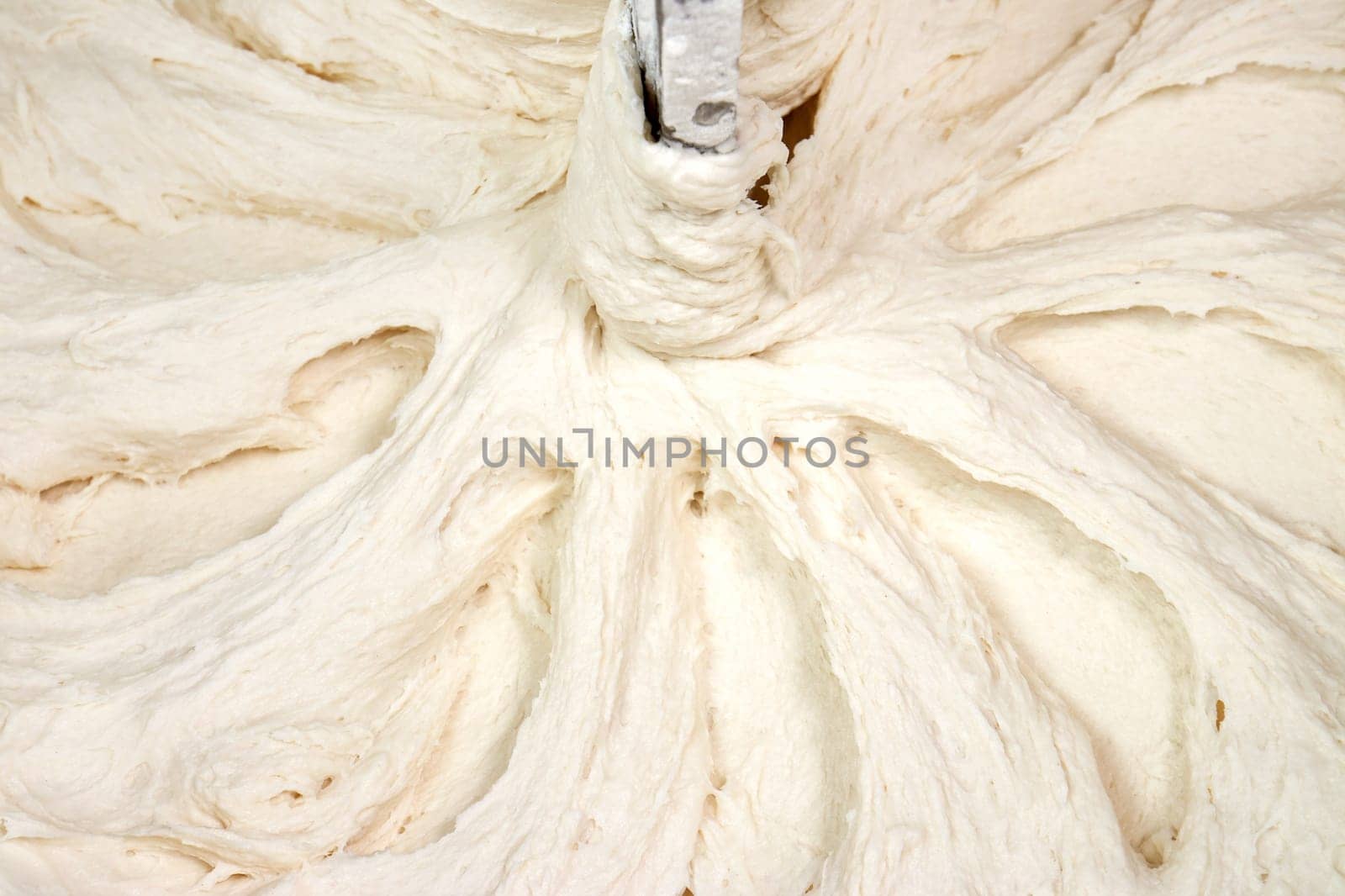 Dough kneading, mixed, in a professional mixer as background
