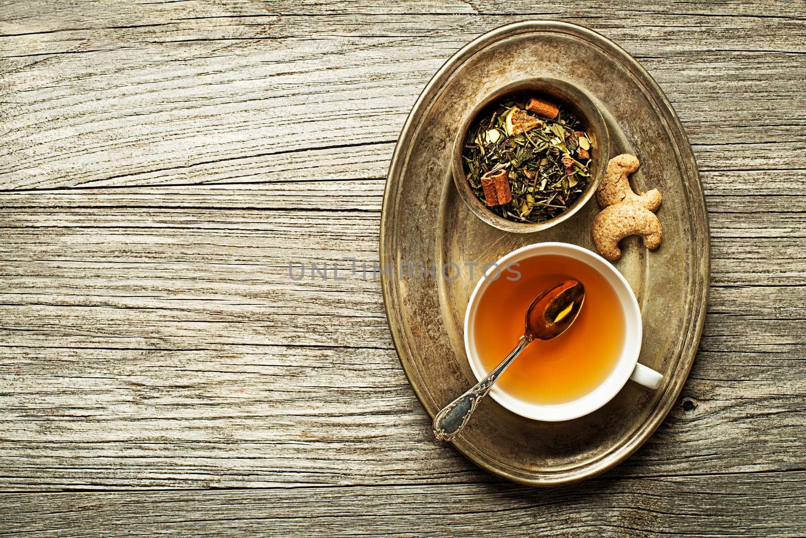 Cup of tea with dry green tea collection on wooden table