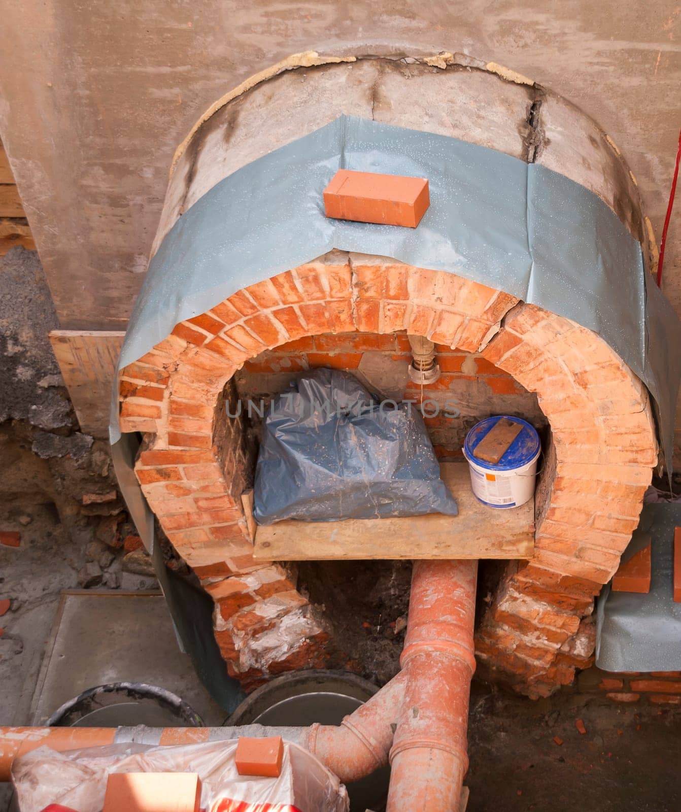 Repair work on the exposed round arch of a sewer.
