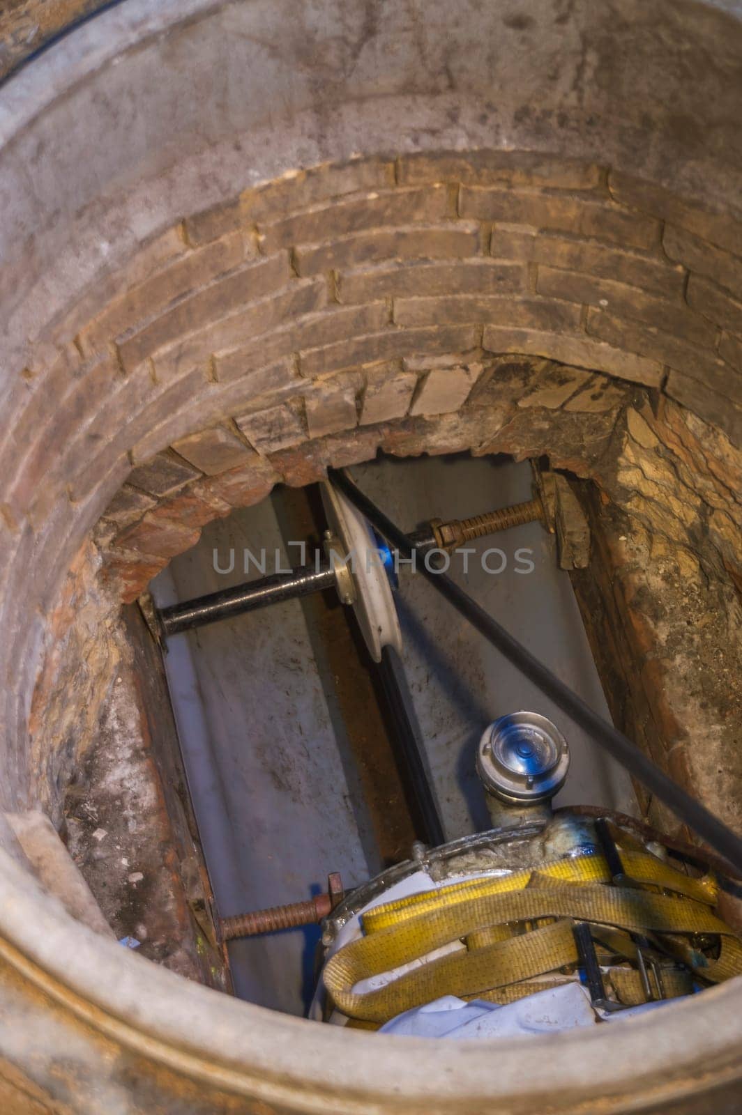 Rehabilitation work on an exposed sewer with manhole and automatic feed unit for drawing in a plastic pipe.