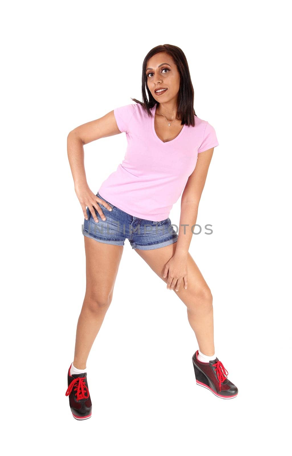 A pretty slim young woman standing in jeans shorts and pink top .looking up, isolated for white background.