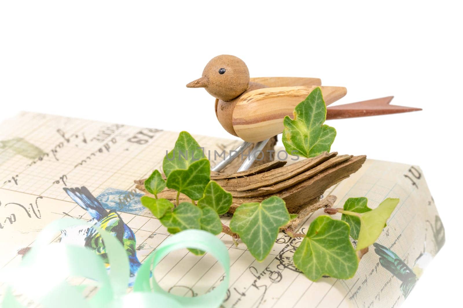 Bright gift box decorated with a wooden bird and bow isolated on white