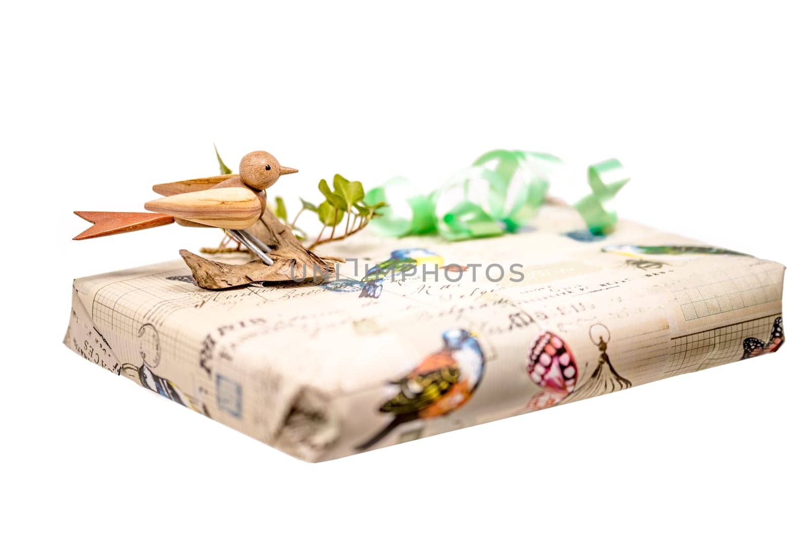 Bright gift box decorated with a wooden bird and bow isolated on white