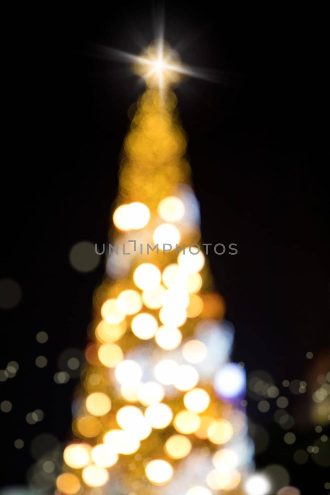 Conceptual background image of defocused abstract Christmas Tree on city street at night