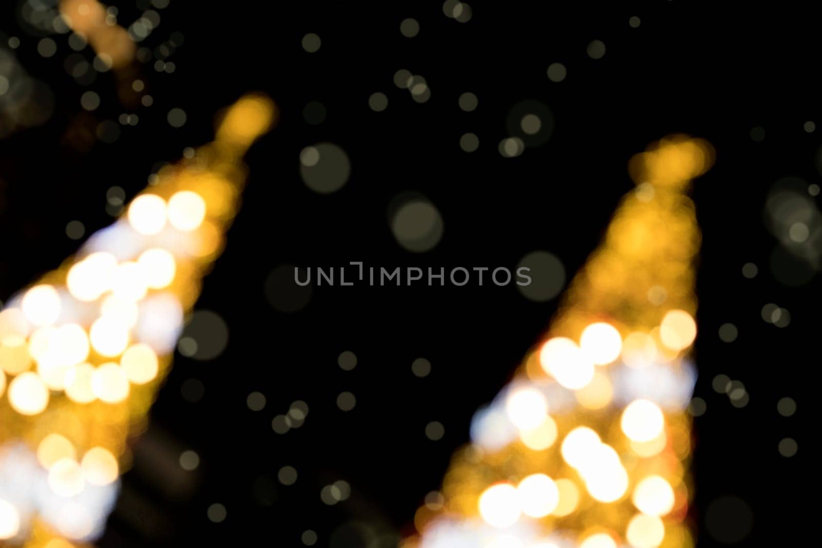 Conceptual background image of defocused abstract Christmas Tree on city street at night